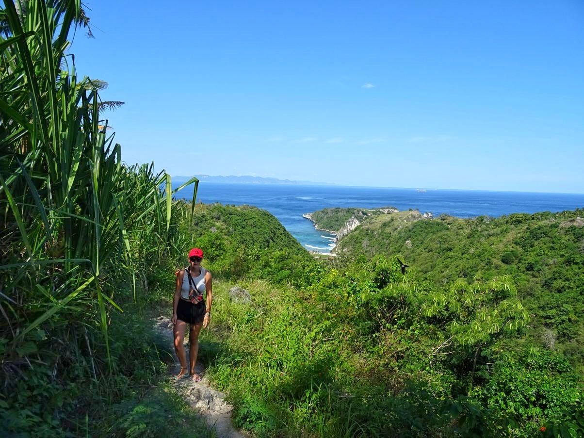 Girl hiking to tropical beach