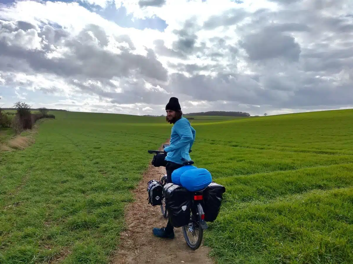 Bicycle tourer cycling through field