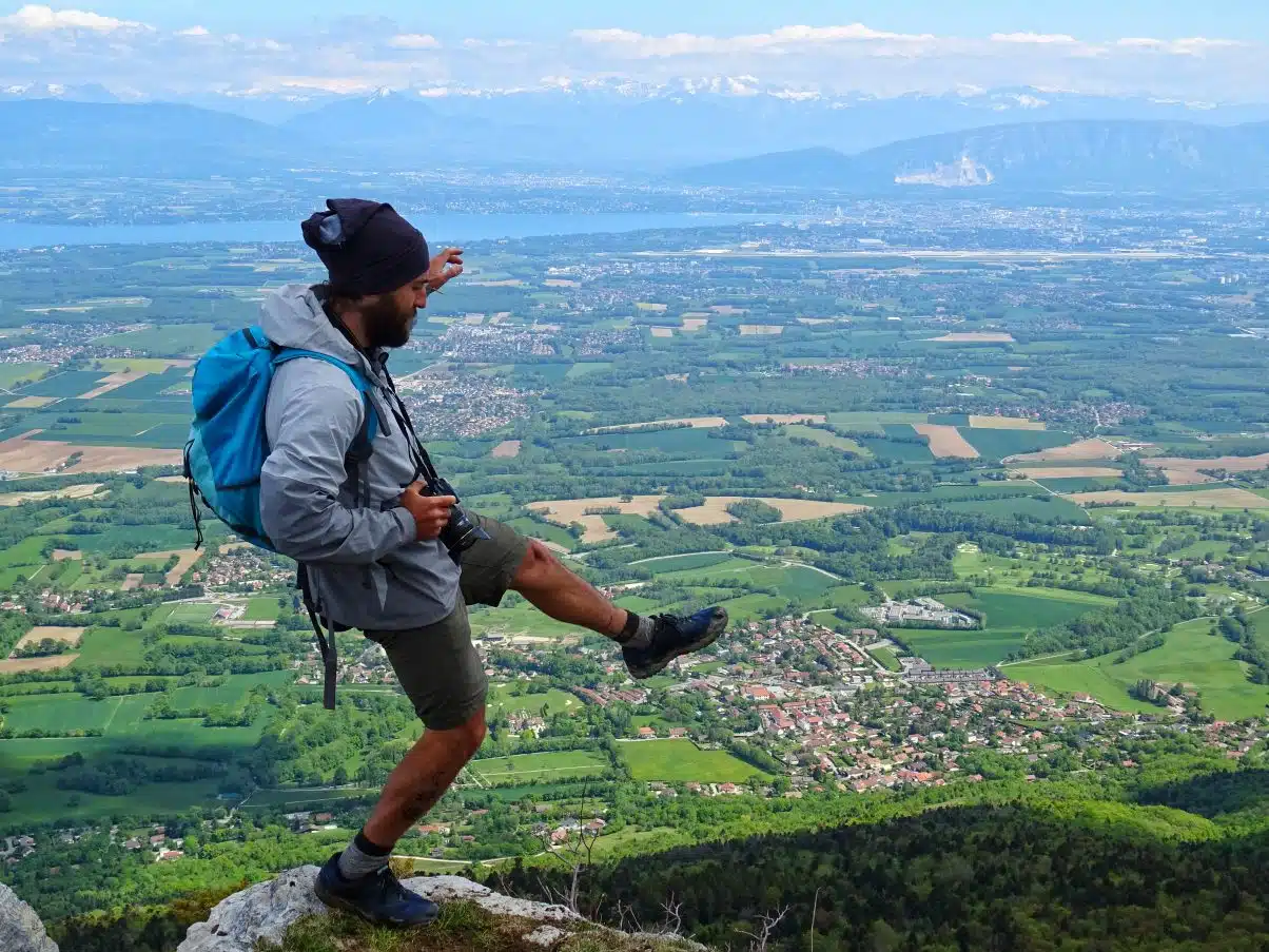 Man hiking stepping over cliff