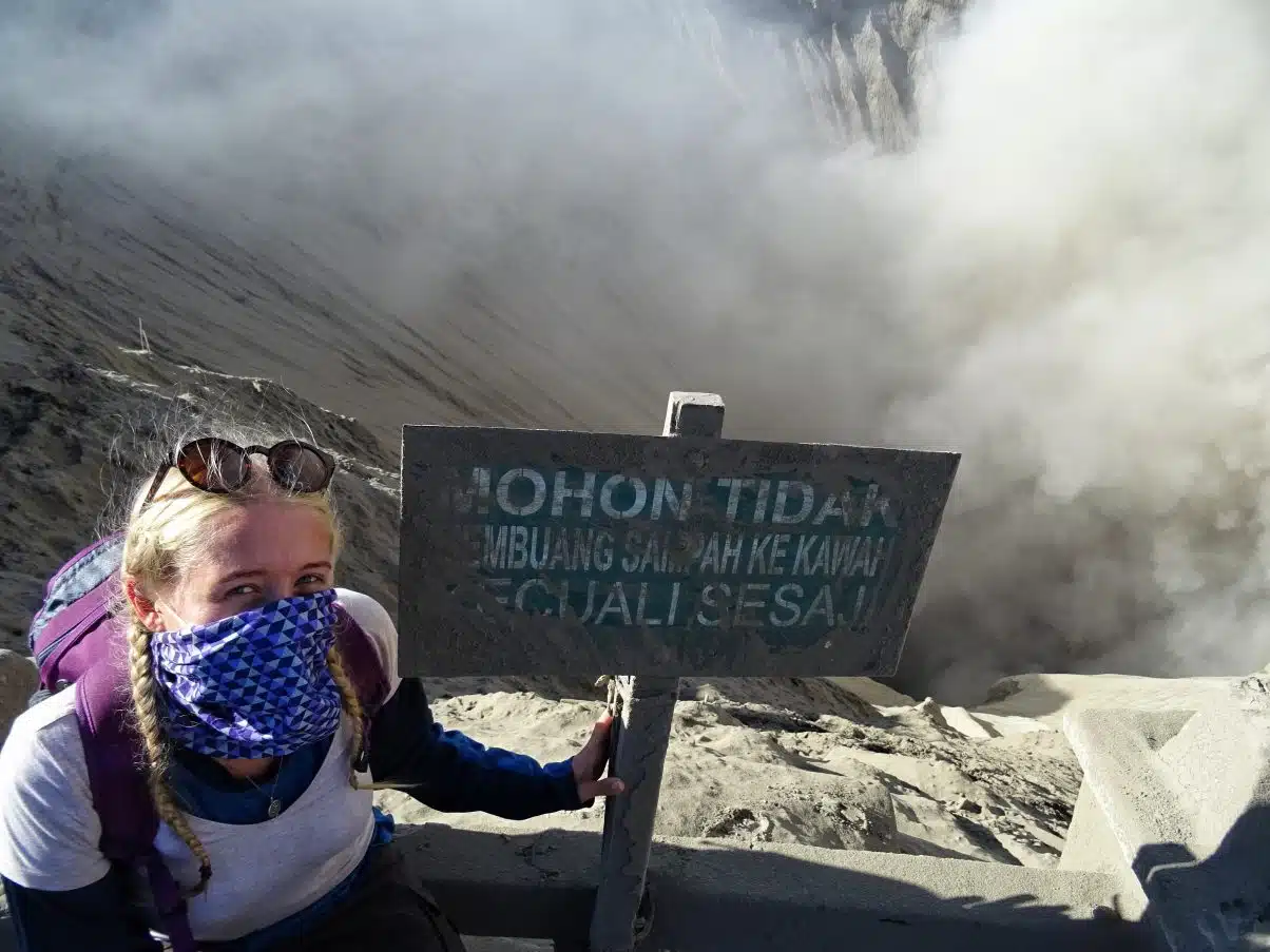 Girl sitting on edge of volcano