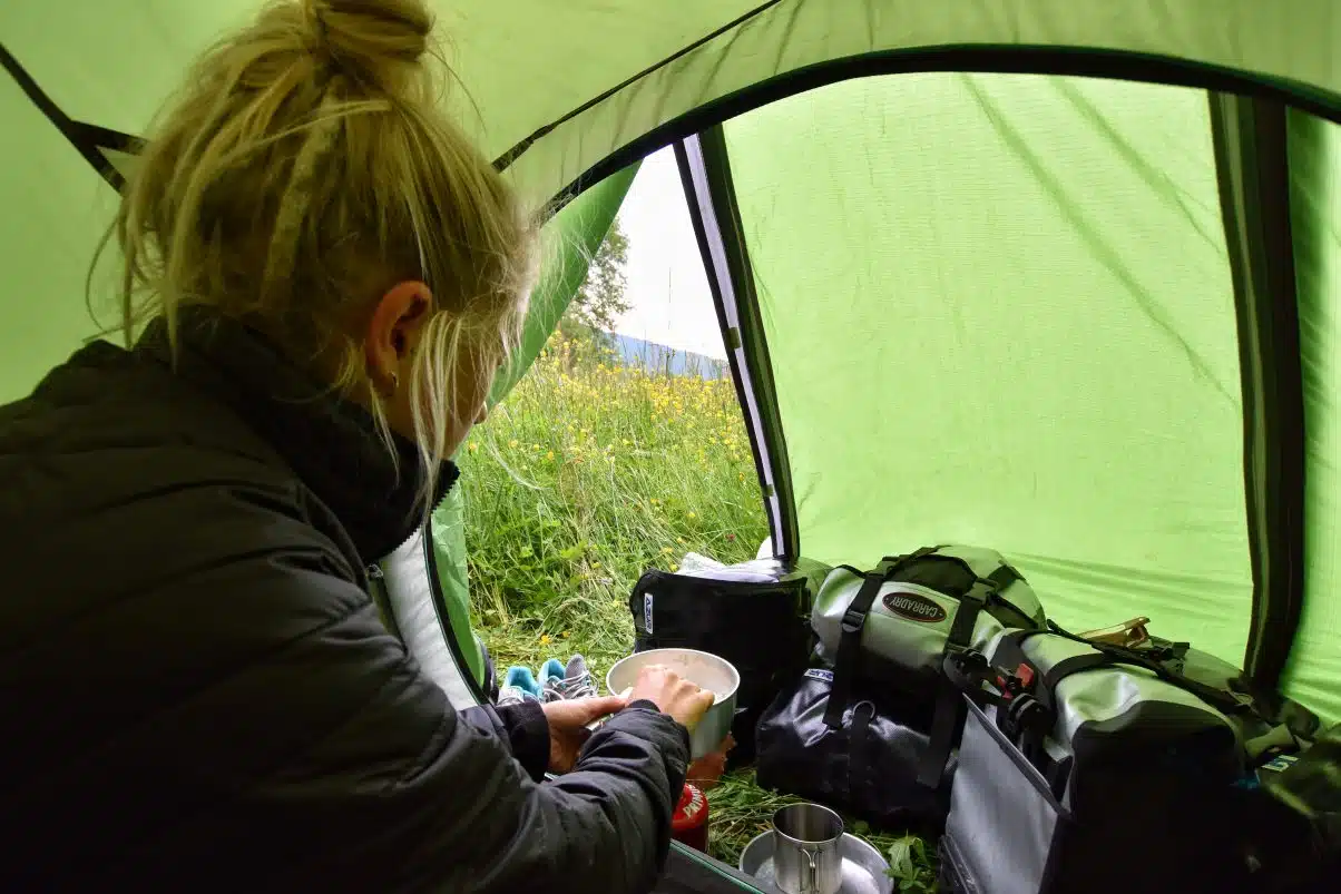 Girl camping and making food in tent 