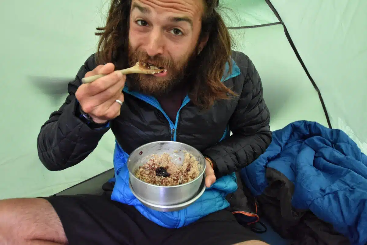 o Homem comer o café da manhã da pan na tenda