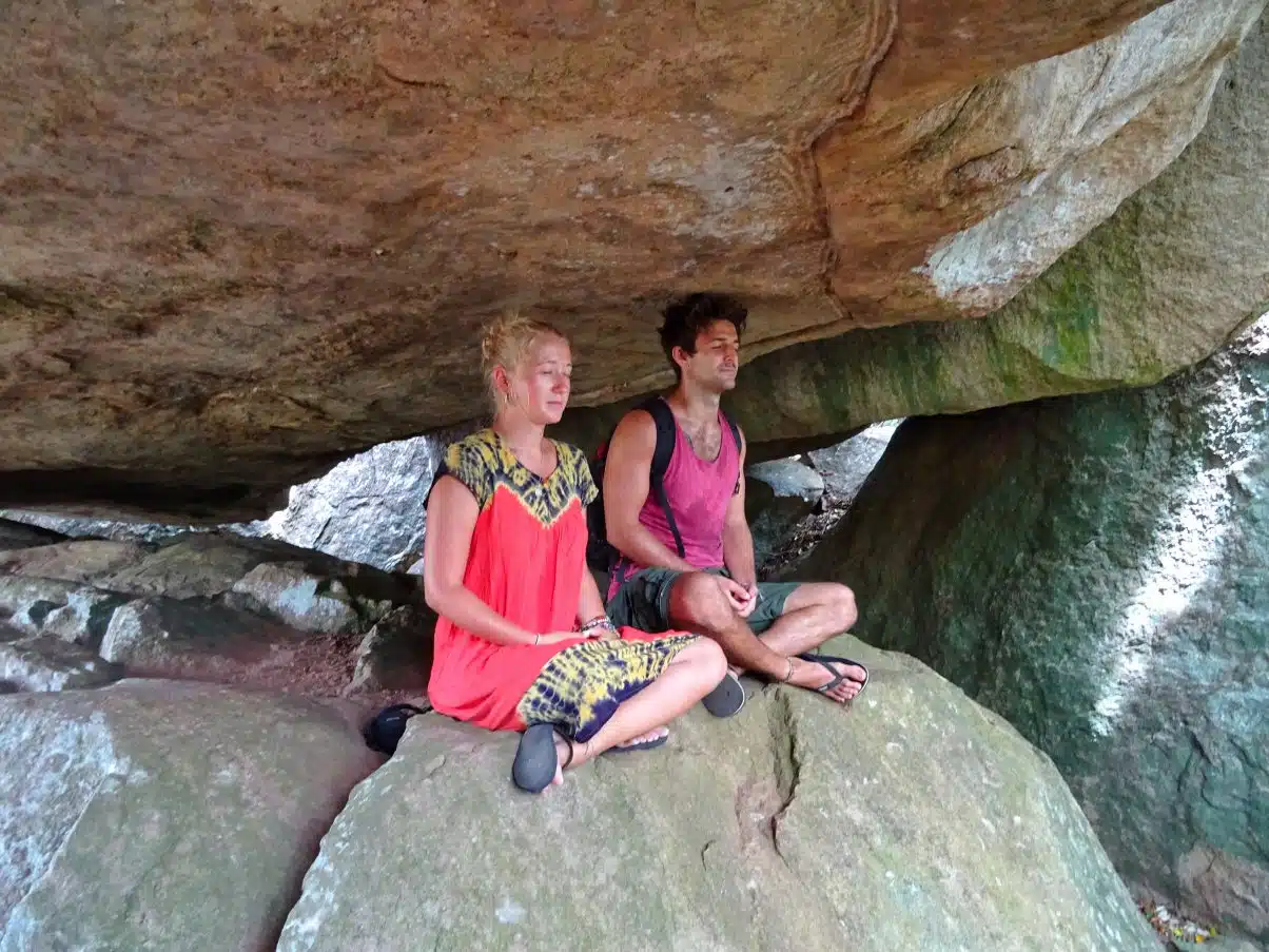 Man and woman meditating whilst spending time in nature 