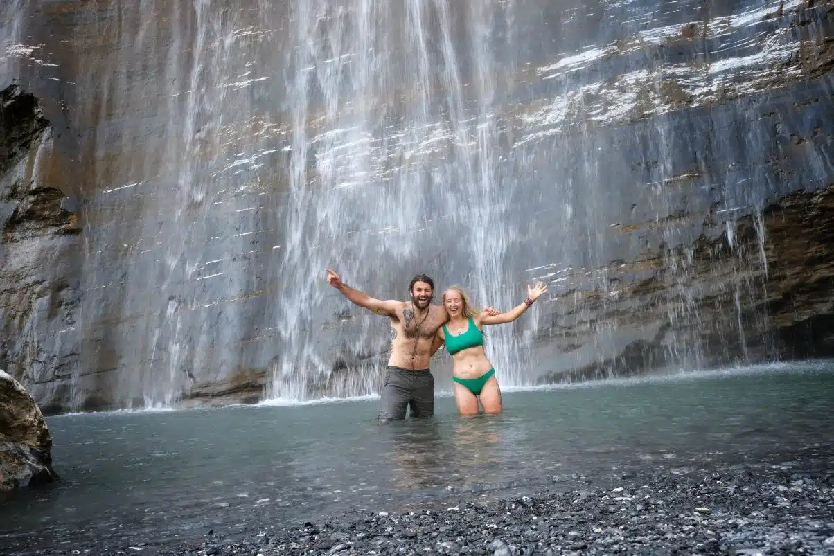 Couple swimming in waterfall