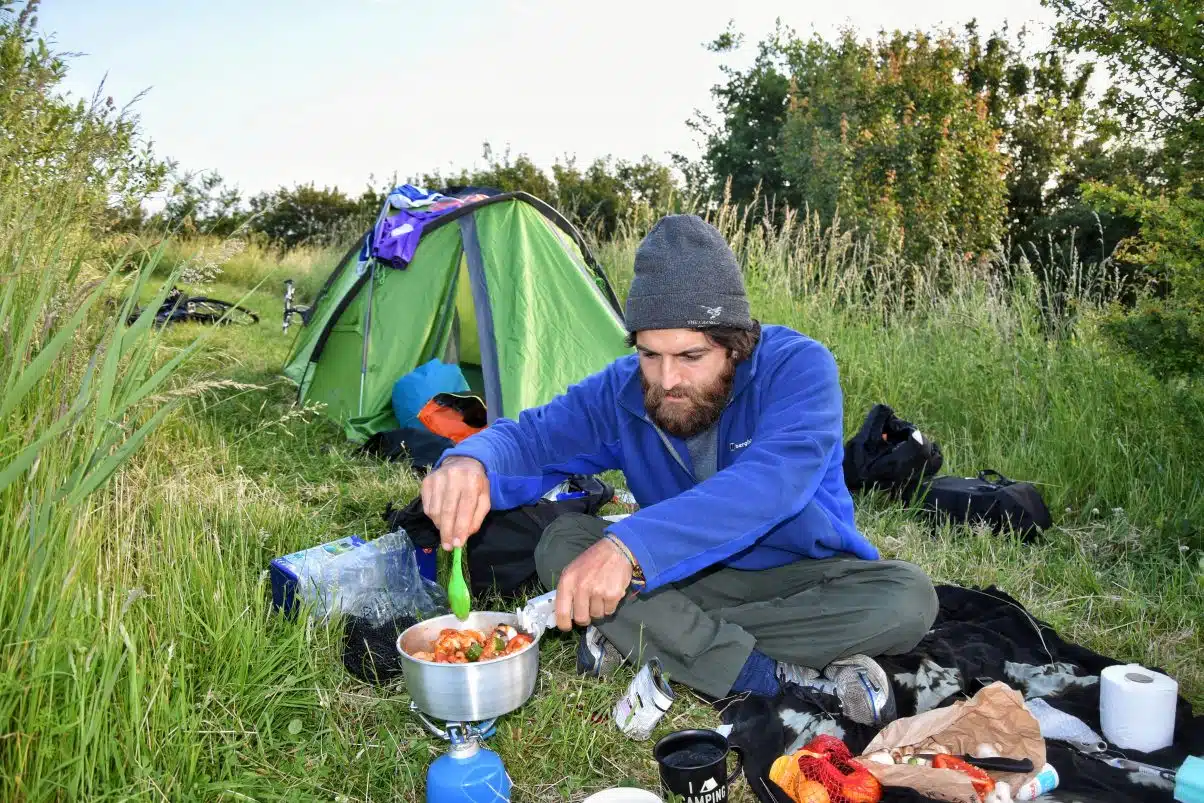 Man cooking with camping equipment 