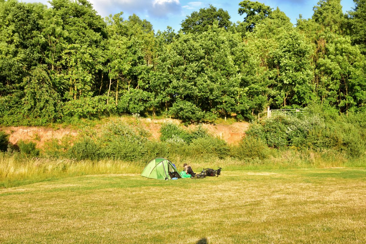 Camping gear and tent in field