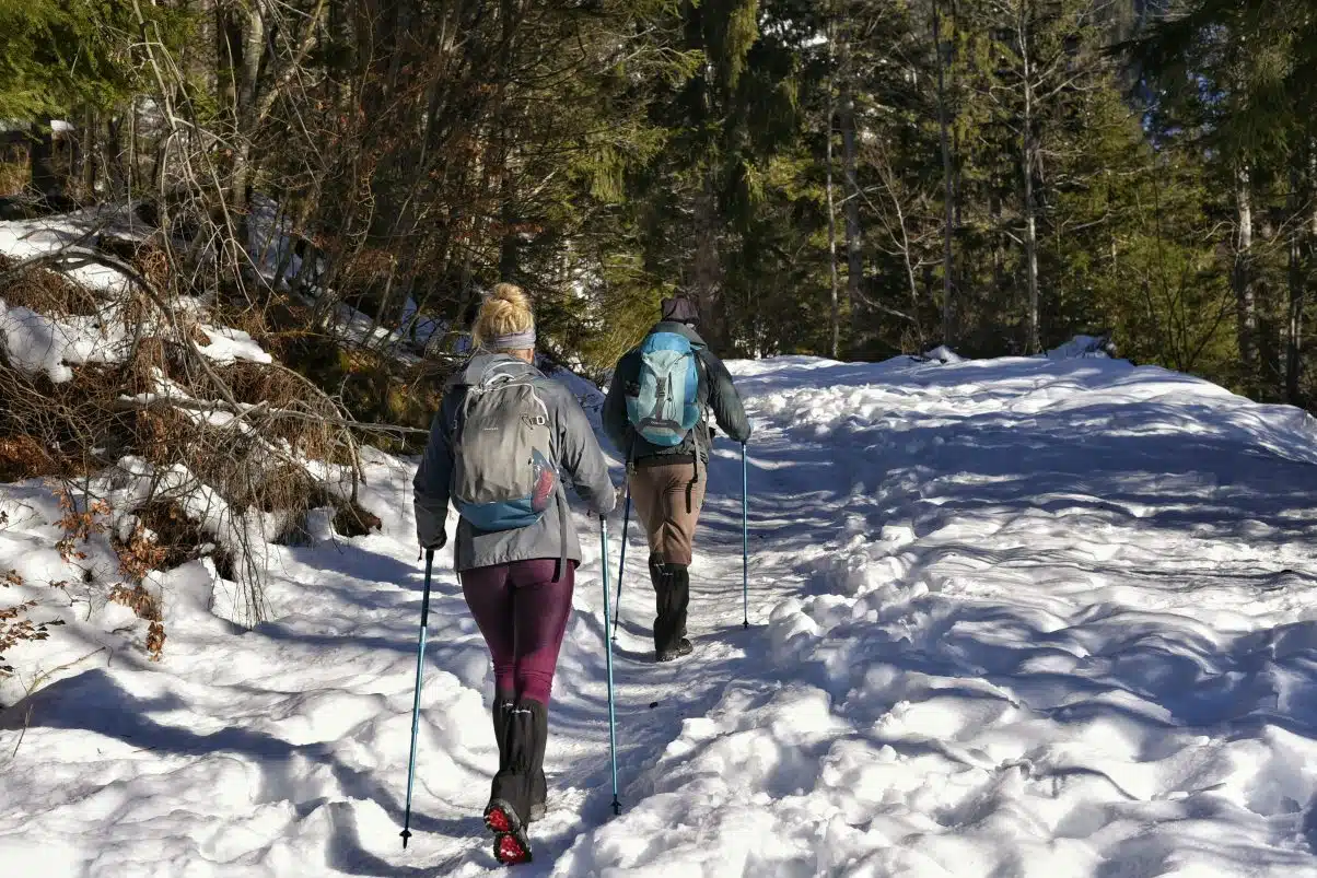 People hiking during winter along mountain path