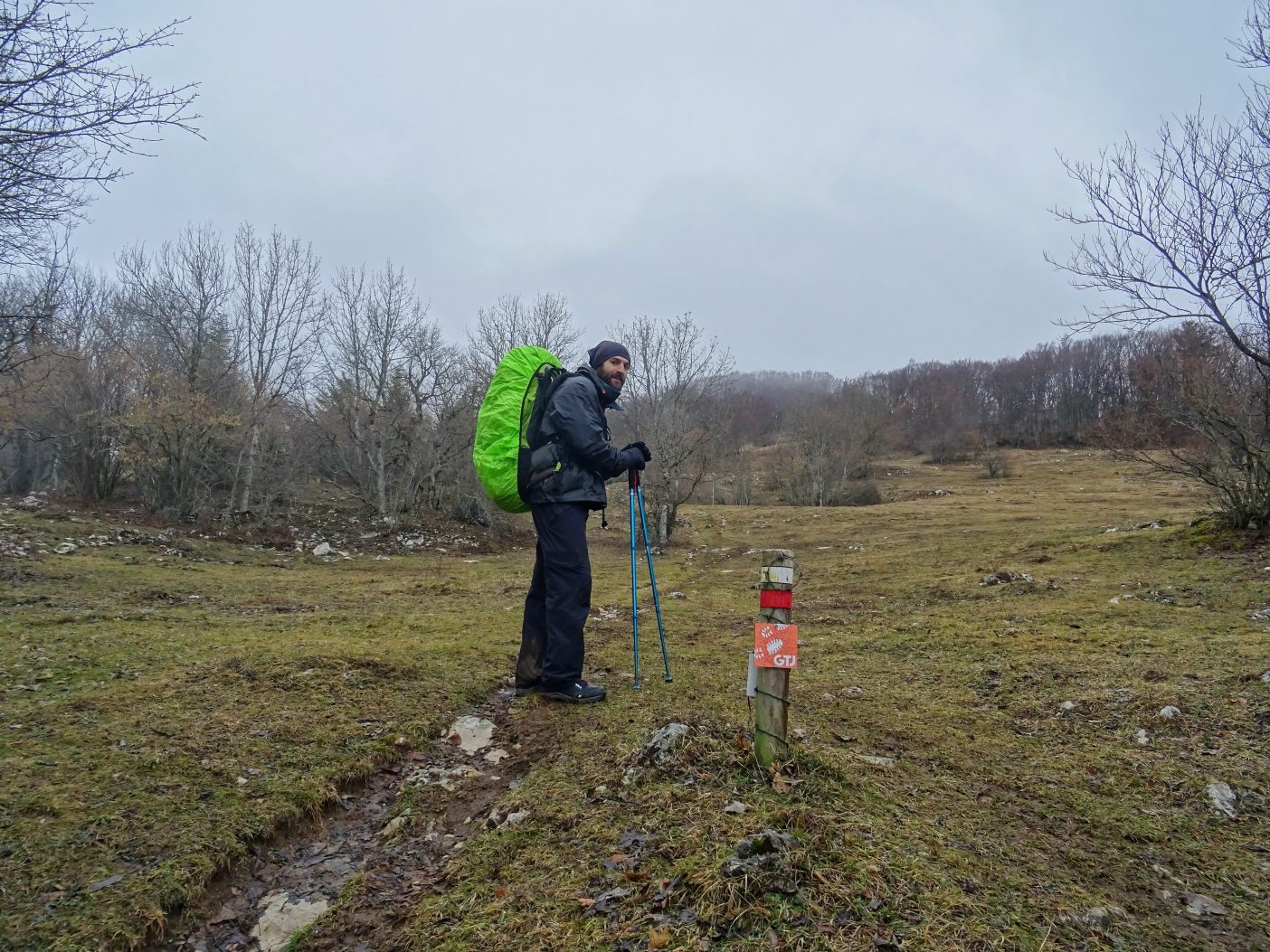 Hiker in the Jura Mountains with large rucksack on 