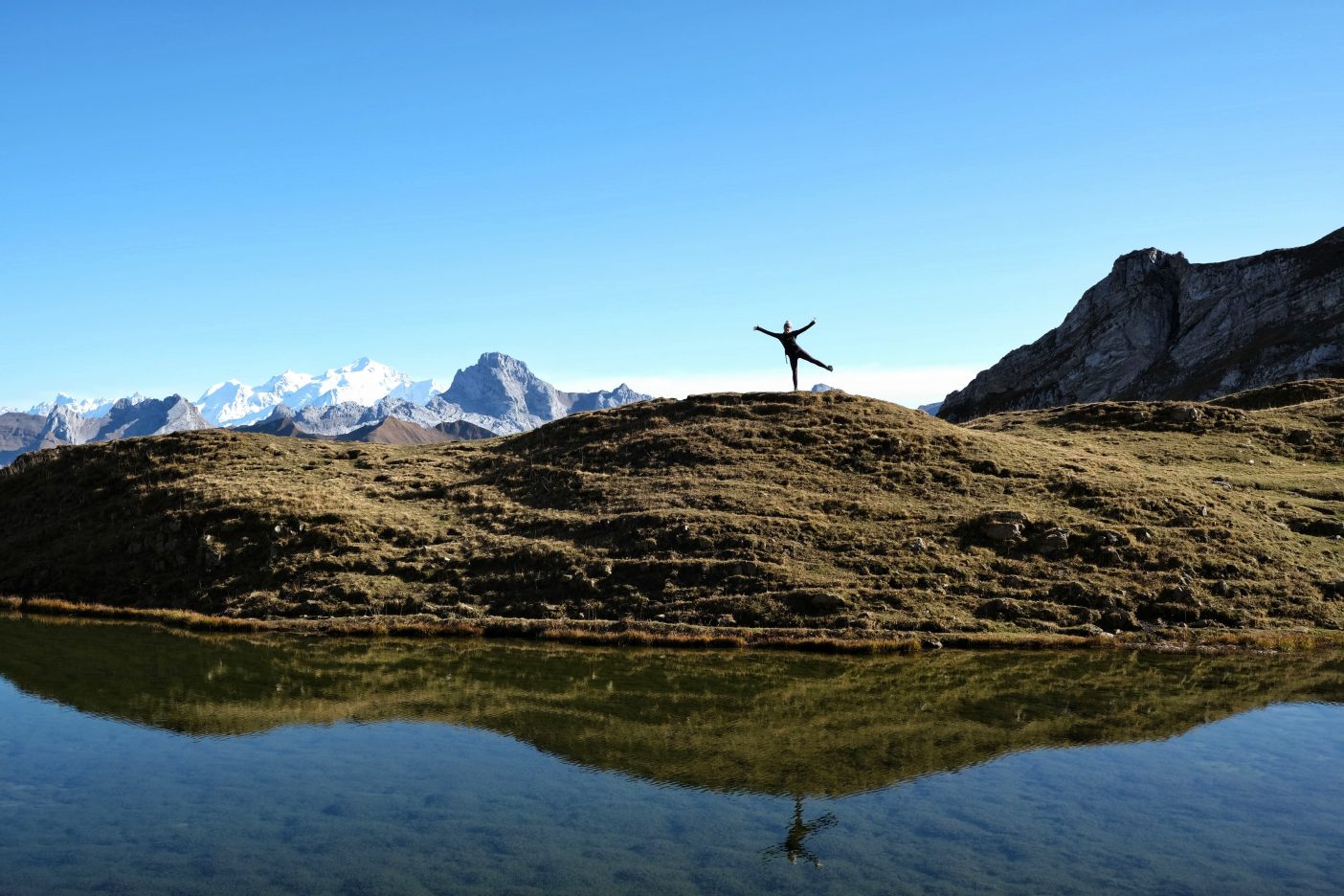 Girl hiking by lake on alpine mountain