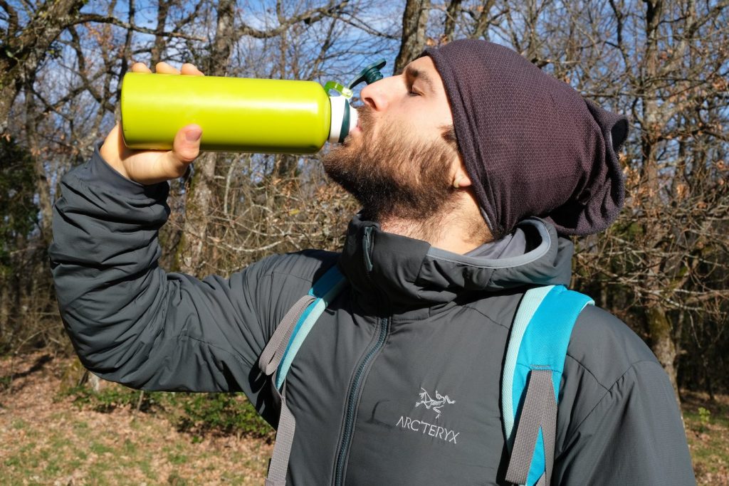 Man drinking from flask in Arc'teryx insulated hoody
