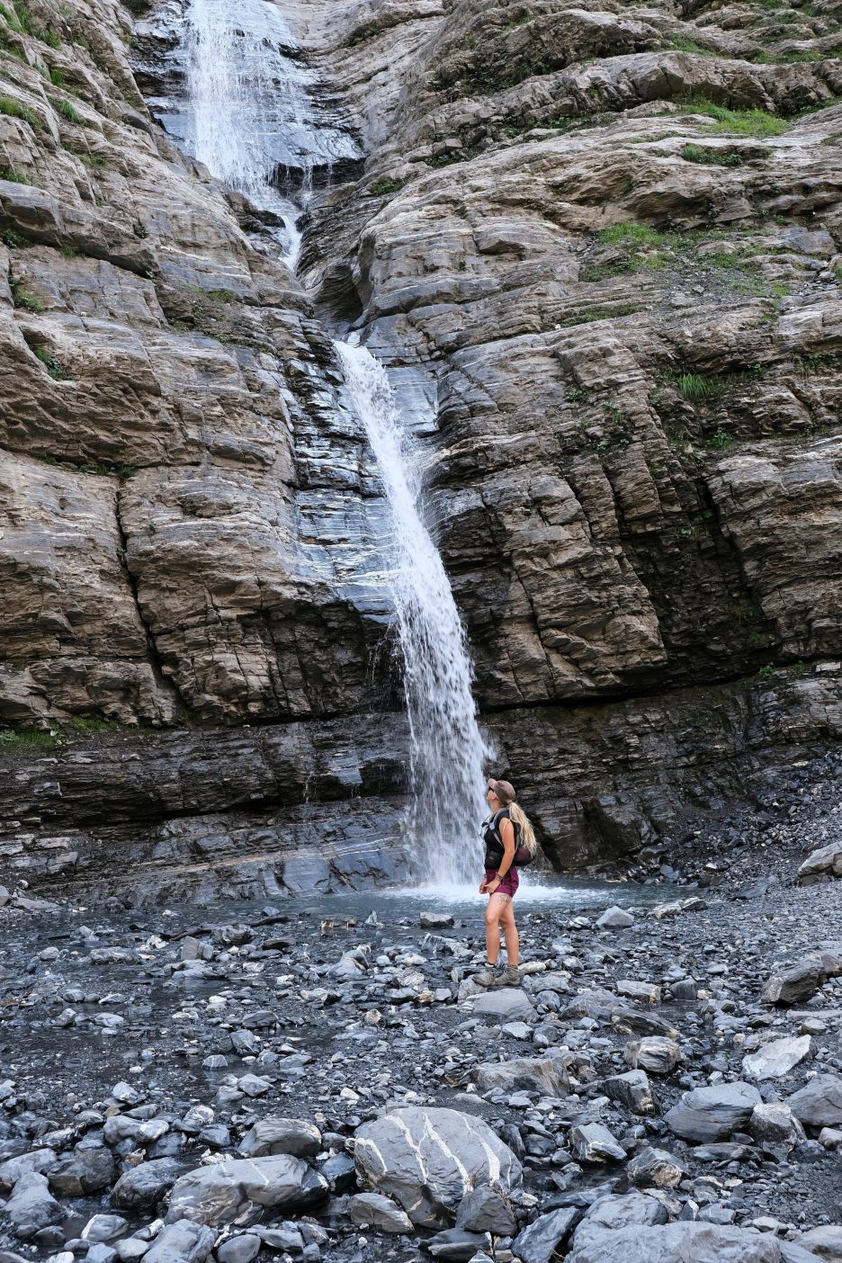 Girl standing next to waterfall 