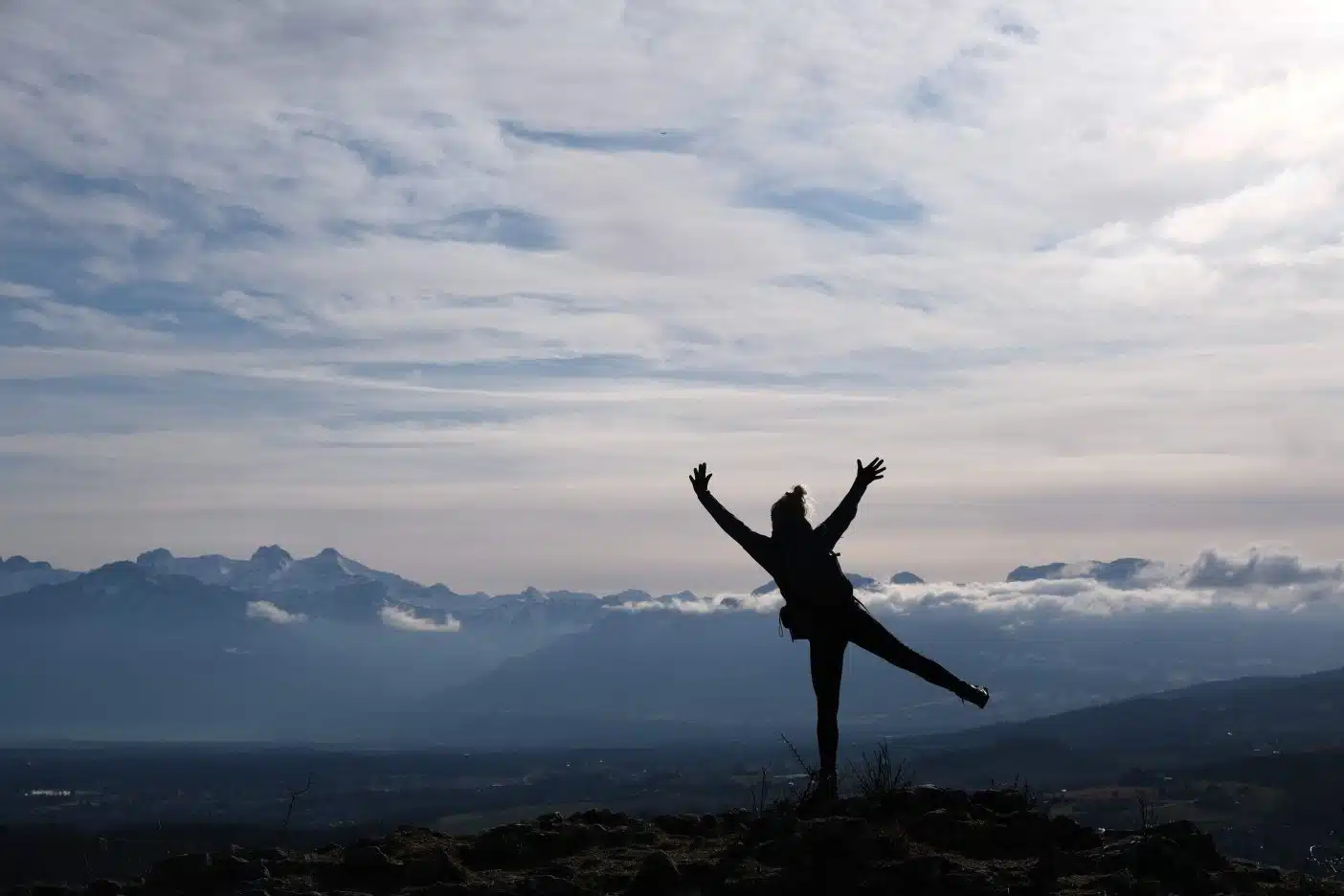Silhouette of girl on top of moutain