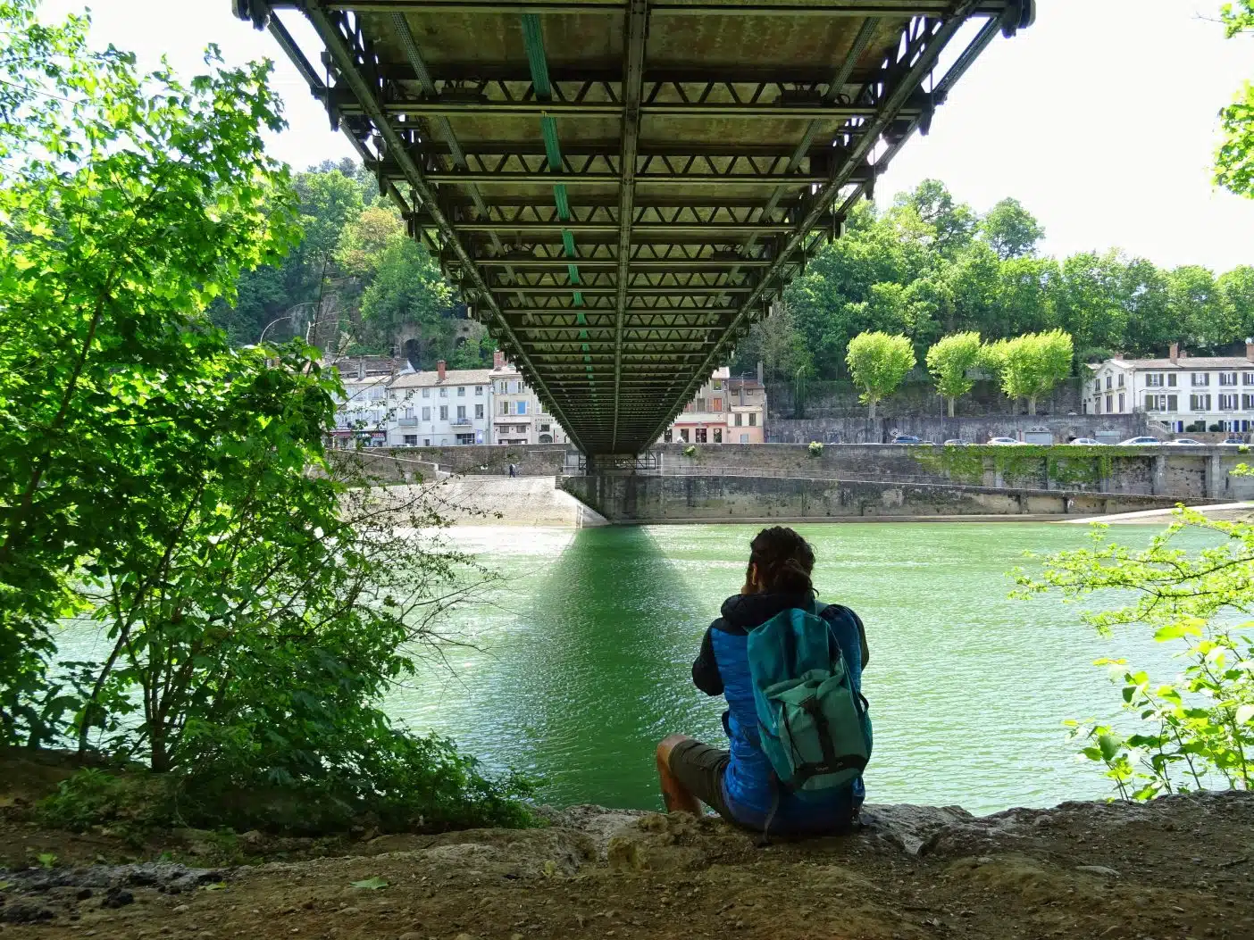 Man sitting under bridge taking photo