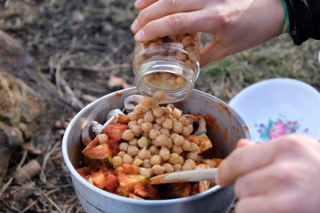 Pouring jar into chickpea curry