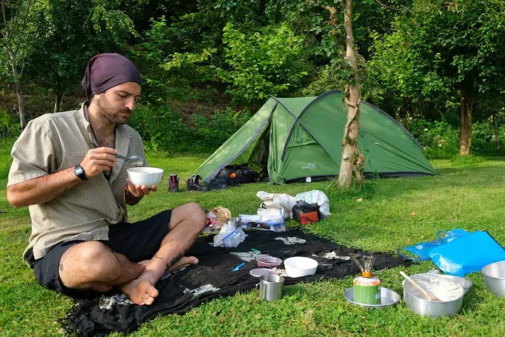 Man eating breakfast outside practising leave no trace camping