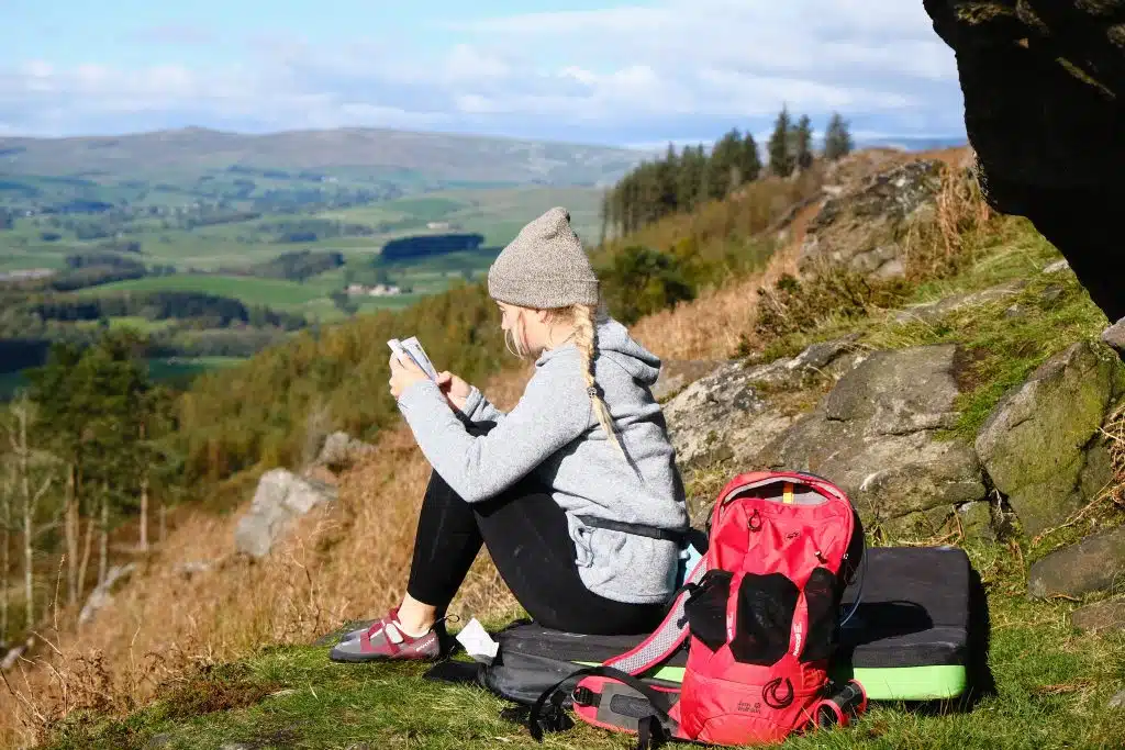 Women sitting on a climbing mat, with an eco-friendly backpack next to her