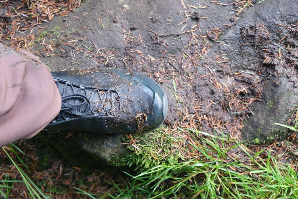 Muddy vegan hiking boot on trail