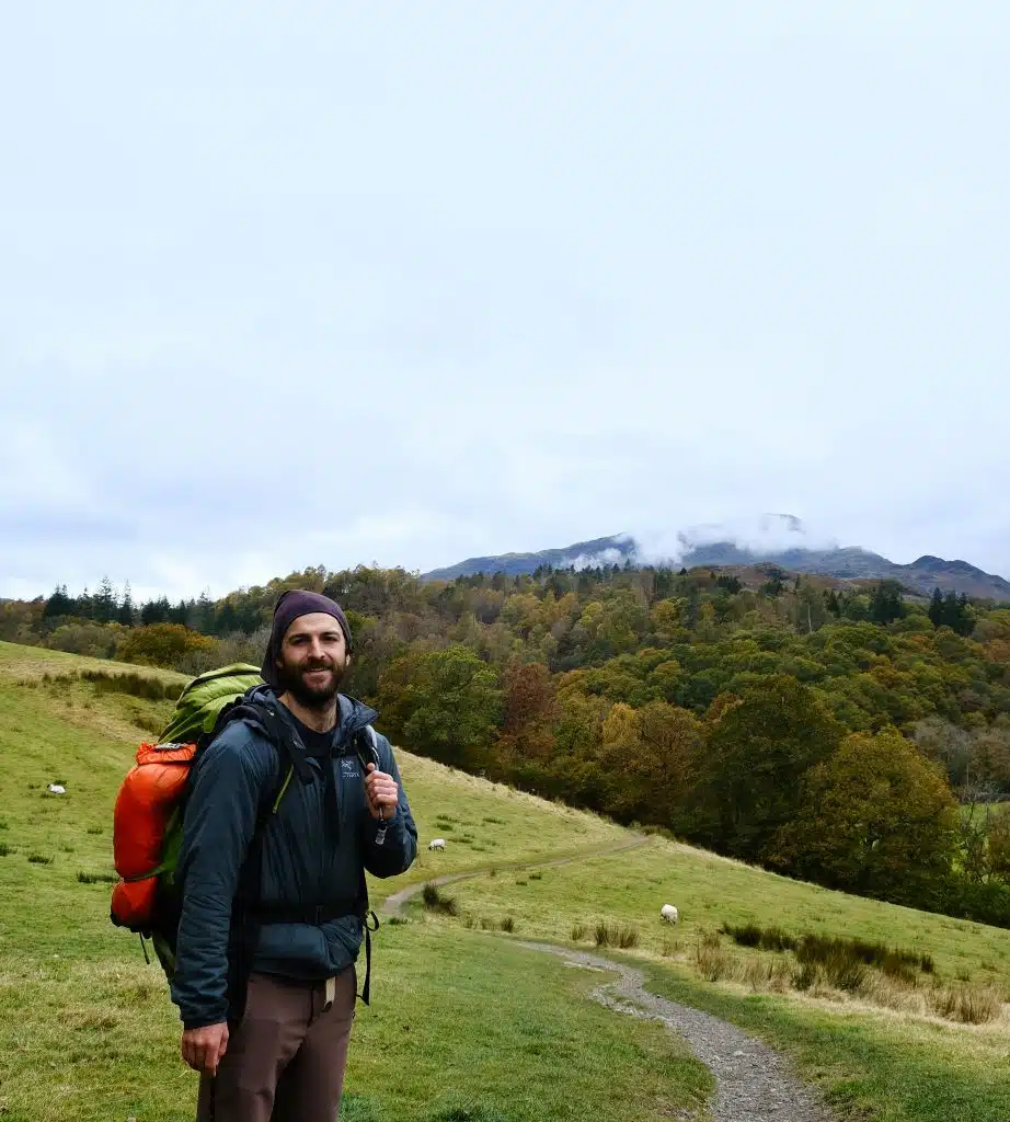 Man backpacking with camping tent strapped to rucksack