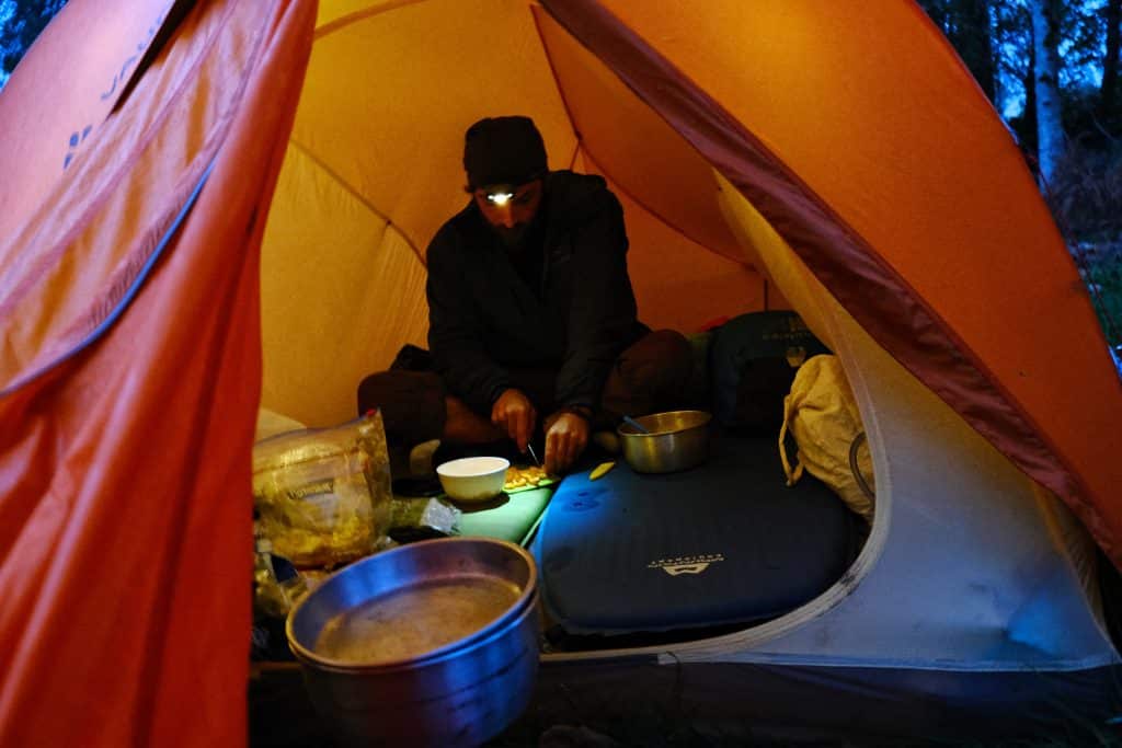 Man cooking in a Vaude tent