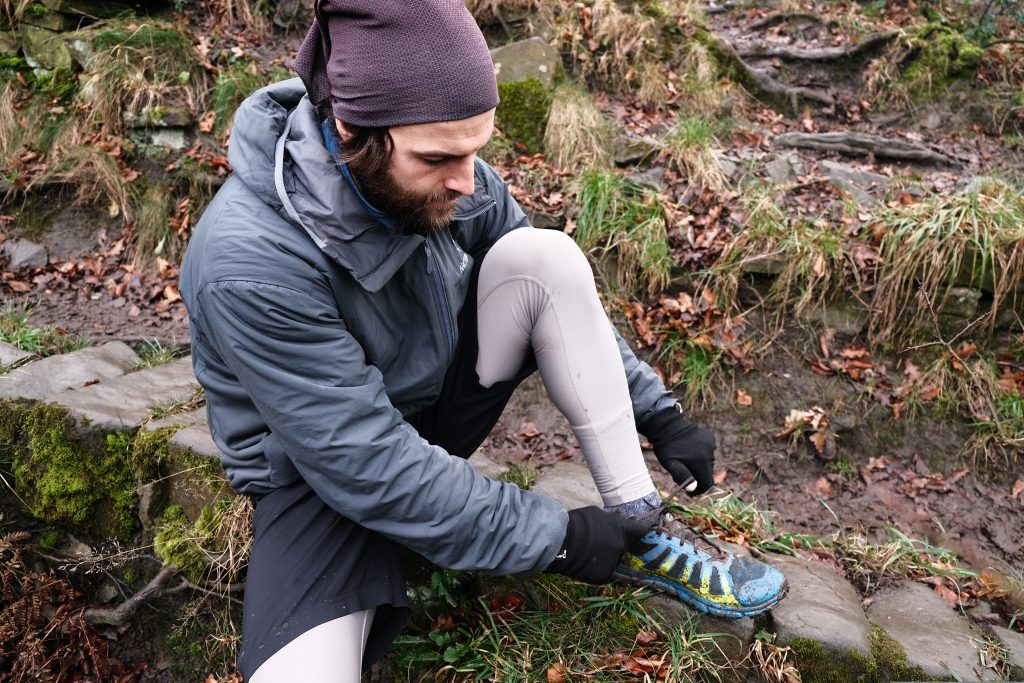 Trail running lacing up a pair of Inov-8 Terraultra G 270