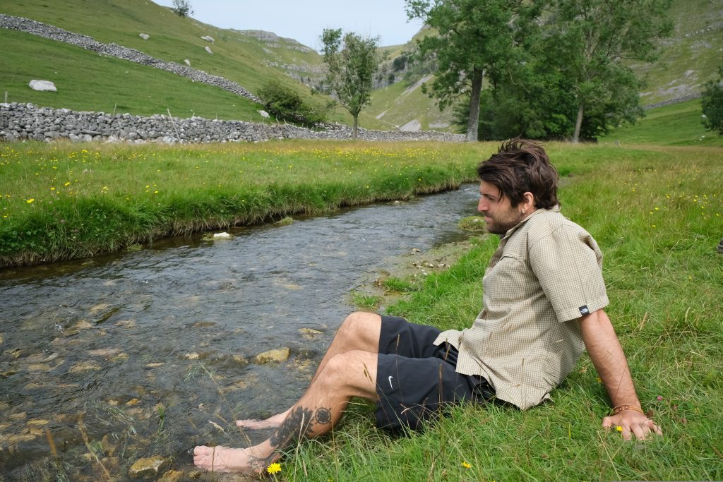 Backpacker cooling feet in river