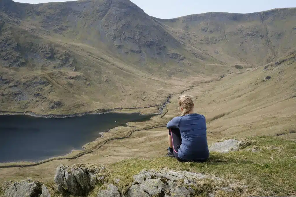 Girl sitting by a reservoir in the lake district