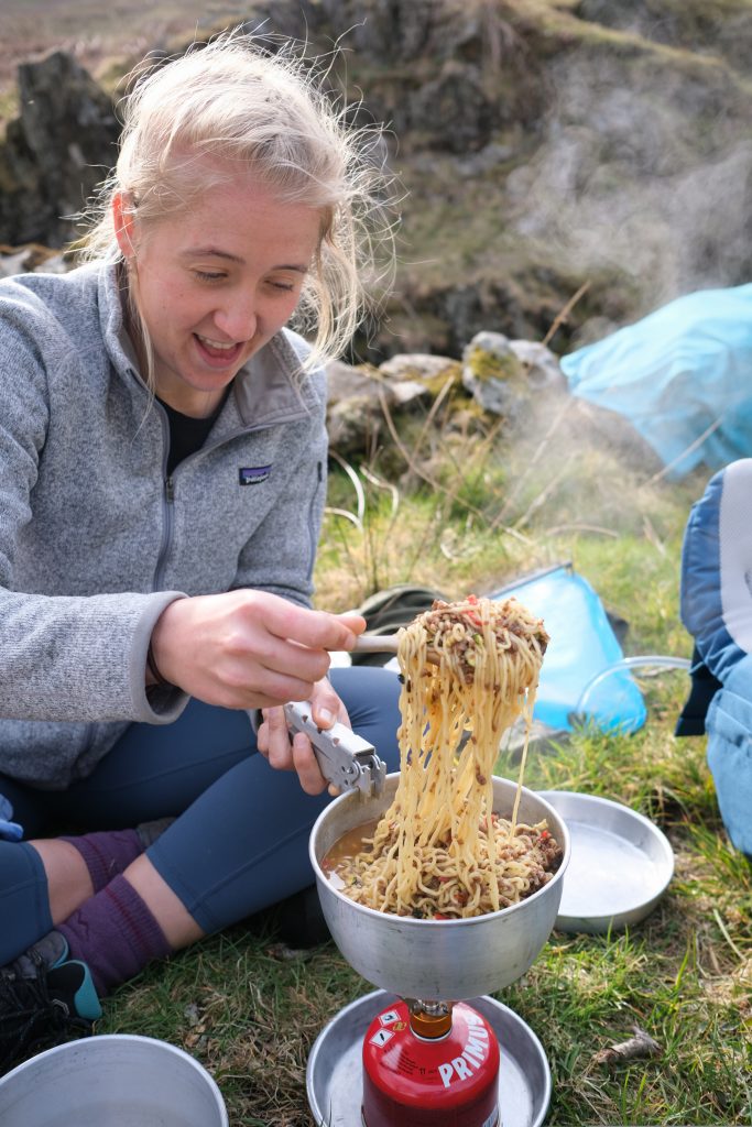 Girl making a camping dinner